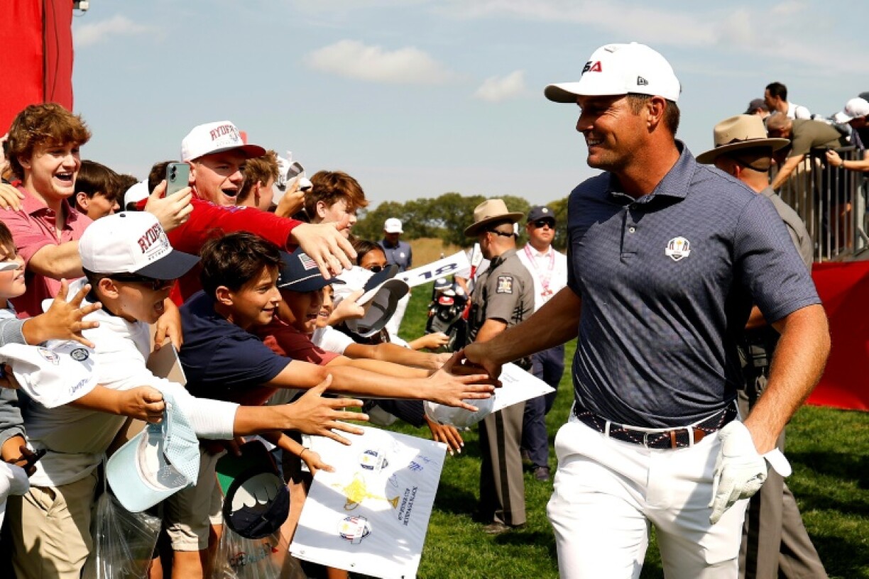 Two-time US Open champion Bryson DeChambeau of the United States high-fives fans during a practice round ahead of the 45th Ryder Cup at Bethpage Black, where he has become a center of controversy