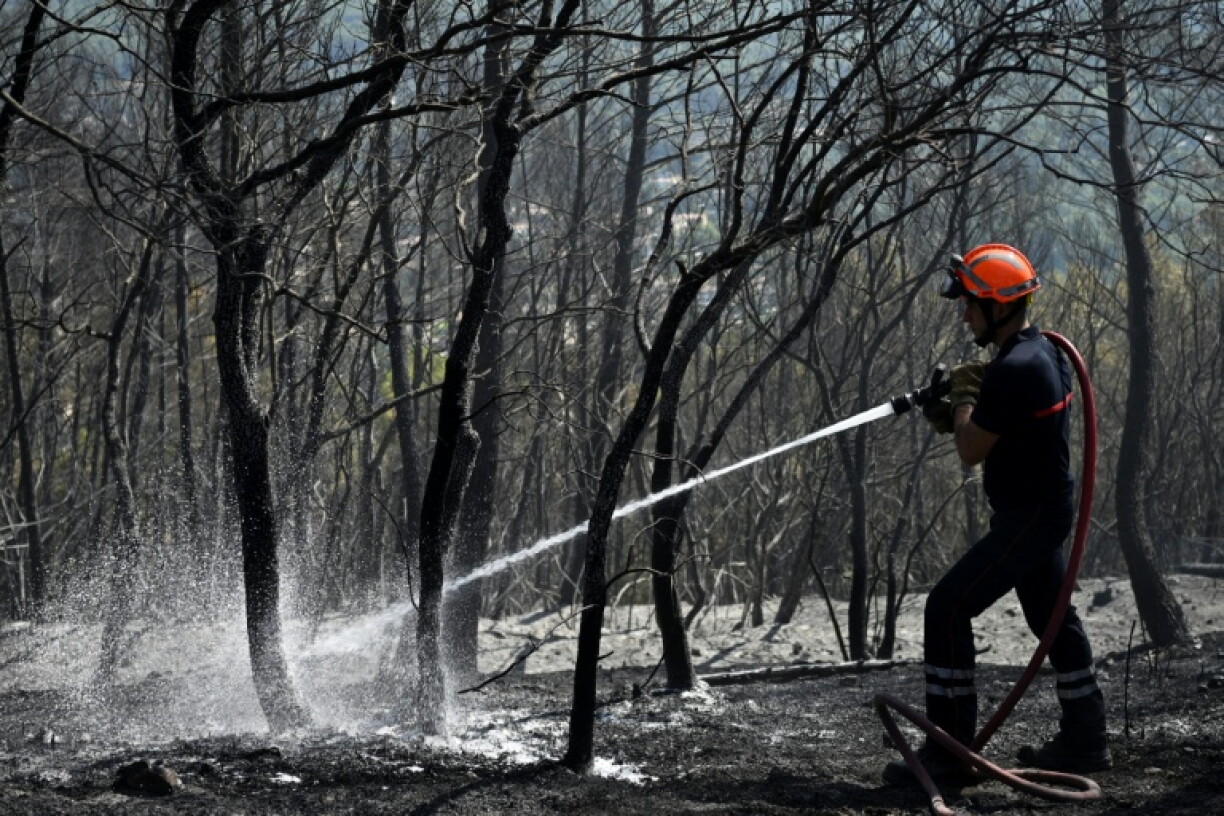 Un pompier arrose une zone brûlée à Cotignac, dans le Var, le 24 juillet 2026