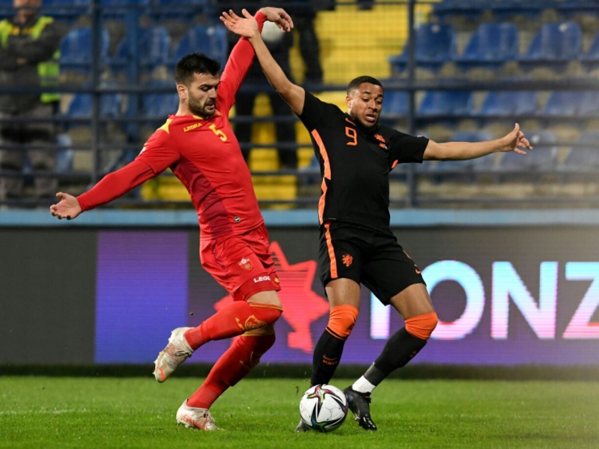 L'attaquant néerlandais Arnaud Groeneveld (d), à la lutte avec le défenseur monténégrin Igor Vujacic, lors des éliminatoires de la Coupe du monde 2022 au Qatar, le 13 novembre 2021 à Podgorica
