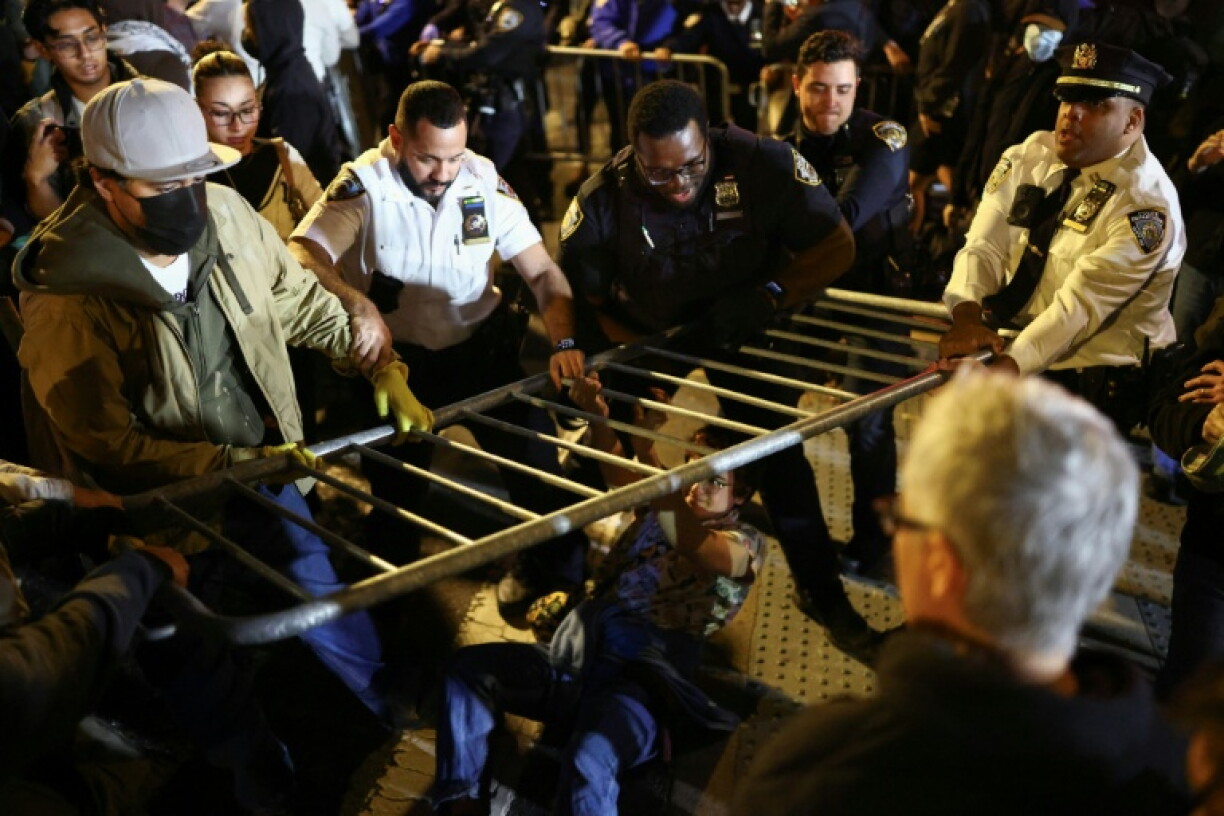 Protesters and law enforcement officers clash close to the scene where a man was shot by an ICE agent