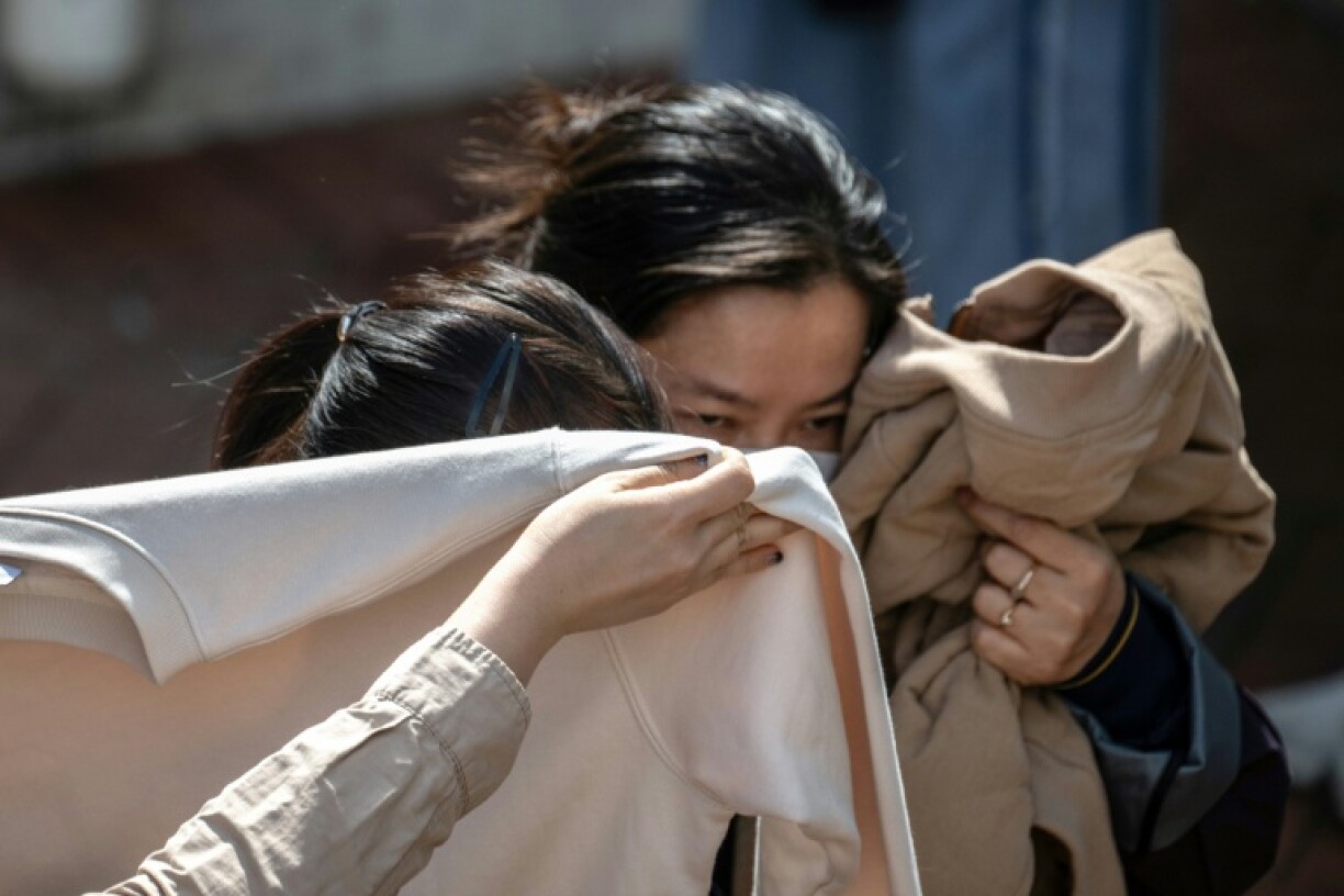 People mourn after identifying bodies in the aftermath of the major fire in Hong Kong's Tai Po district