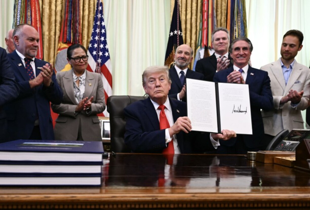 US President Donald Trump displays a proclamation on American commercial fishing in the Pacific in the Oval Office of the White House in Washington, DC, on June 11, 2026