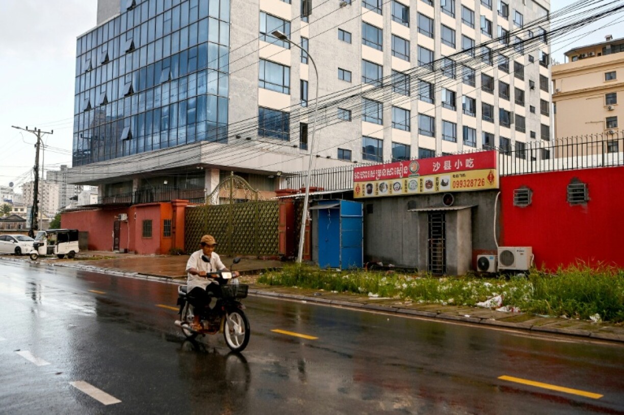 A motorist passes a building in 2022 that was previously shut down by the police in Cambodia's coastal city of Sihanoukville