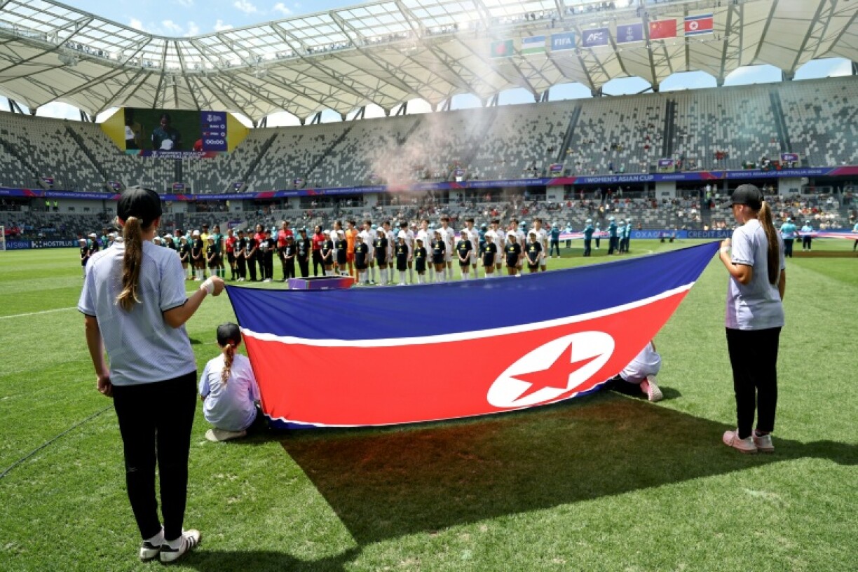 Les joueuses du Bangladesh et de la Corée du Nord derrière le drapeau national nord-coréen avant le coup d'envoi du match de la Coupe d'Asie féminine de l'AFC 2026 en Australie opposant le Bangladesh à la Corée du Nord, à Sydney, le 6 mars 2026