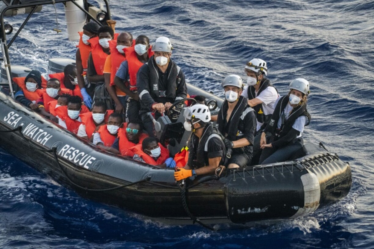 Des migrants du bateau Louise Michel, affrété par l'artiste de rue Banksy, sont emmenés par des membres d'équipage du bateau humanitaire Sea-Watch 4 lors d'une opération de secours, le 29 août 2020 au large des côtes maltaises.