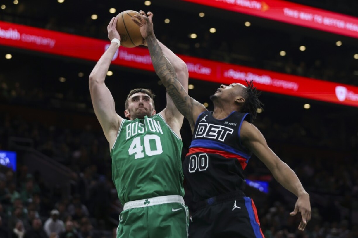 Luke Kornet of the Boston Celtics battles for the ball with Ronald Holland II of Detroit in the Celtics' NBA victory over the Pistons