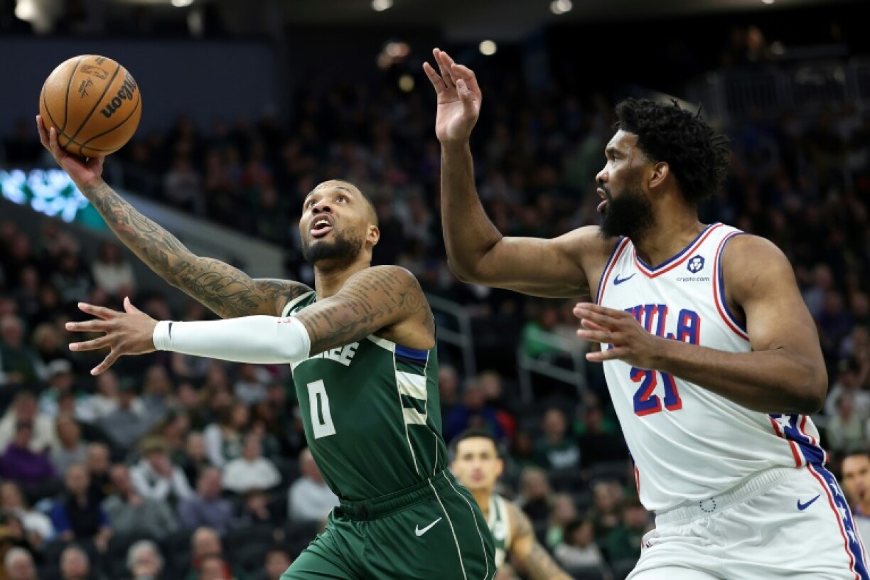 Damian Lillard of the Milwaukee Bucks drives to the basket against Joel Embiid in the Bucks' NBA victory over the Philadelphia 76ers