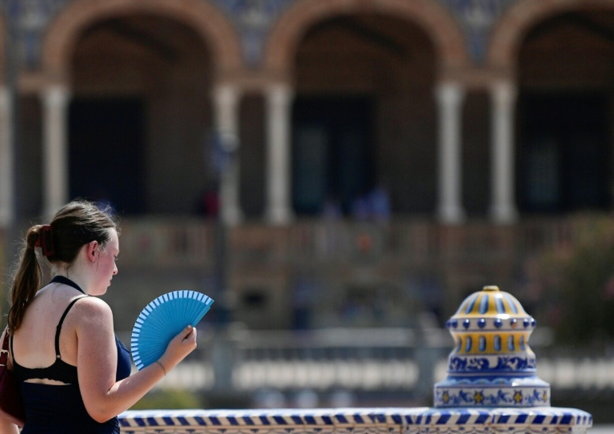 A woman fans herself during a heatwave in Seville in August