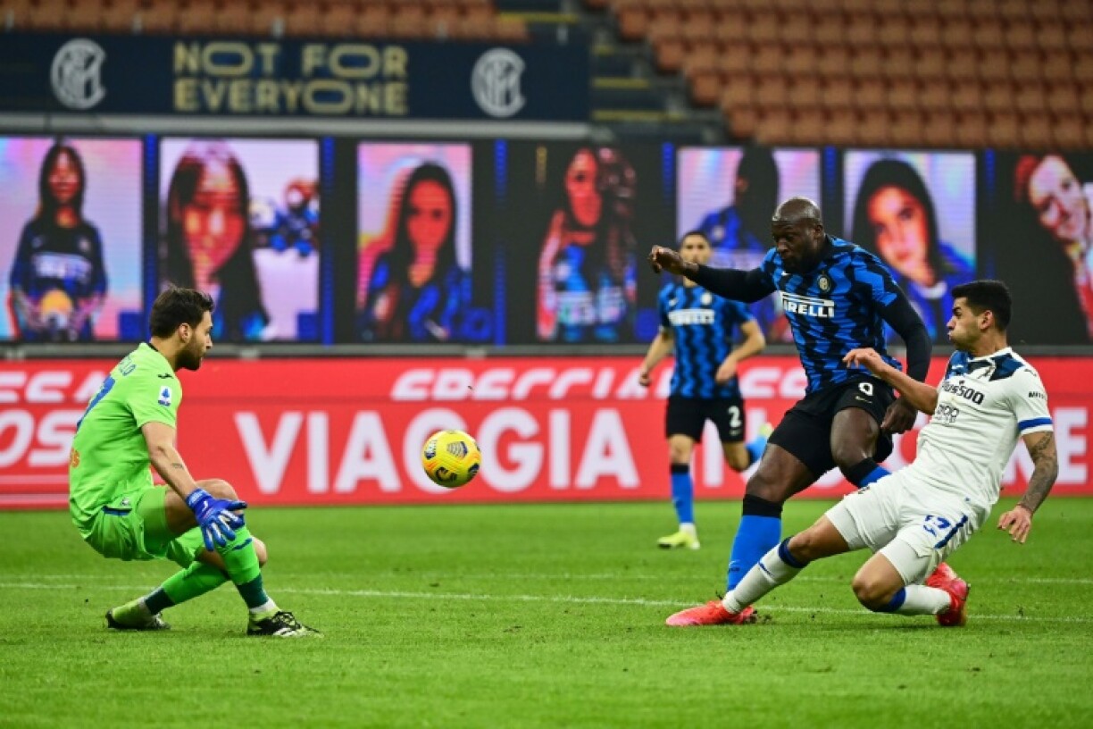 Le défenseur argentin de l'Atalanta Bergame, Cristian Romero, dégage le ballon devant l'attaquant belge de l'Inter Milan, Romelu Lukaku, lors de leur match de Série A, le 8 mars 2021 au stade San Siro à Milan