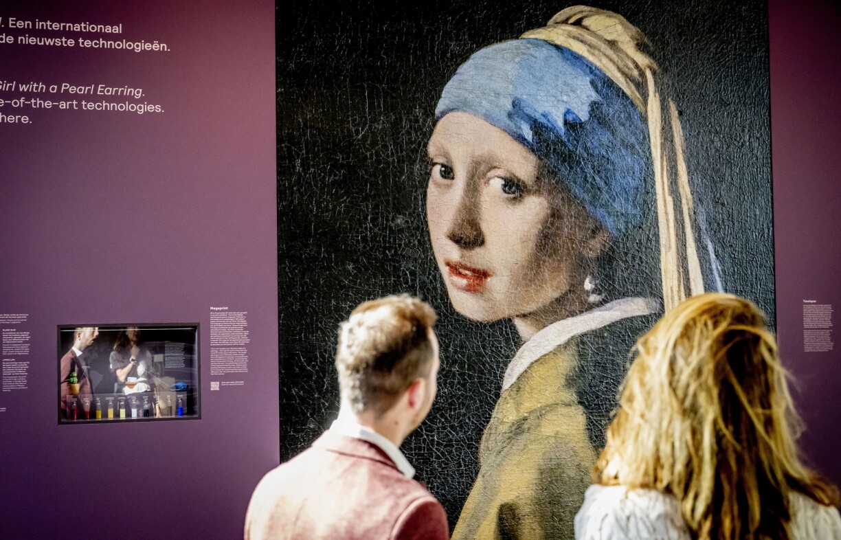 Visitors look at a 4-meter-high 3D print of Johannes Vermeer's painting