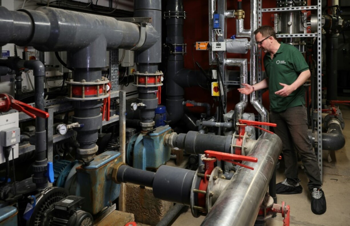 Mark Bjornsgaard, PDG de l'entreprise Deep Green, explique le fonctionnement d'une installation récupérant la chaleur générée par des ordinateurs pour chauffer la piscine du centre de loisirs d'Exmouth, le 13 juin 2023 dans le sud-ouest de l'Angleterre