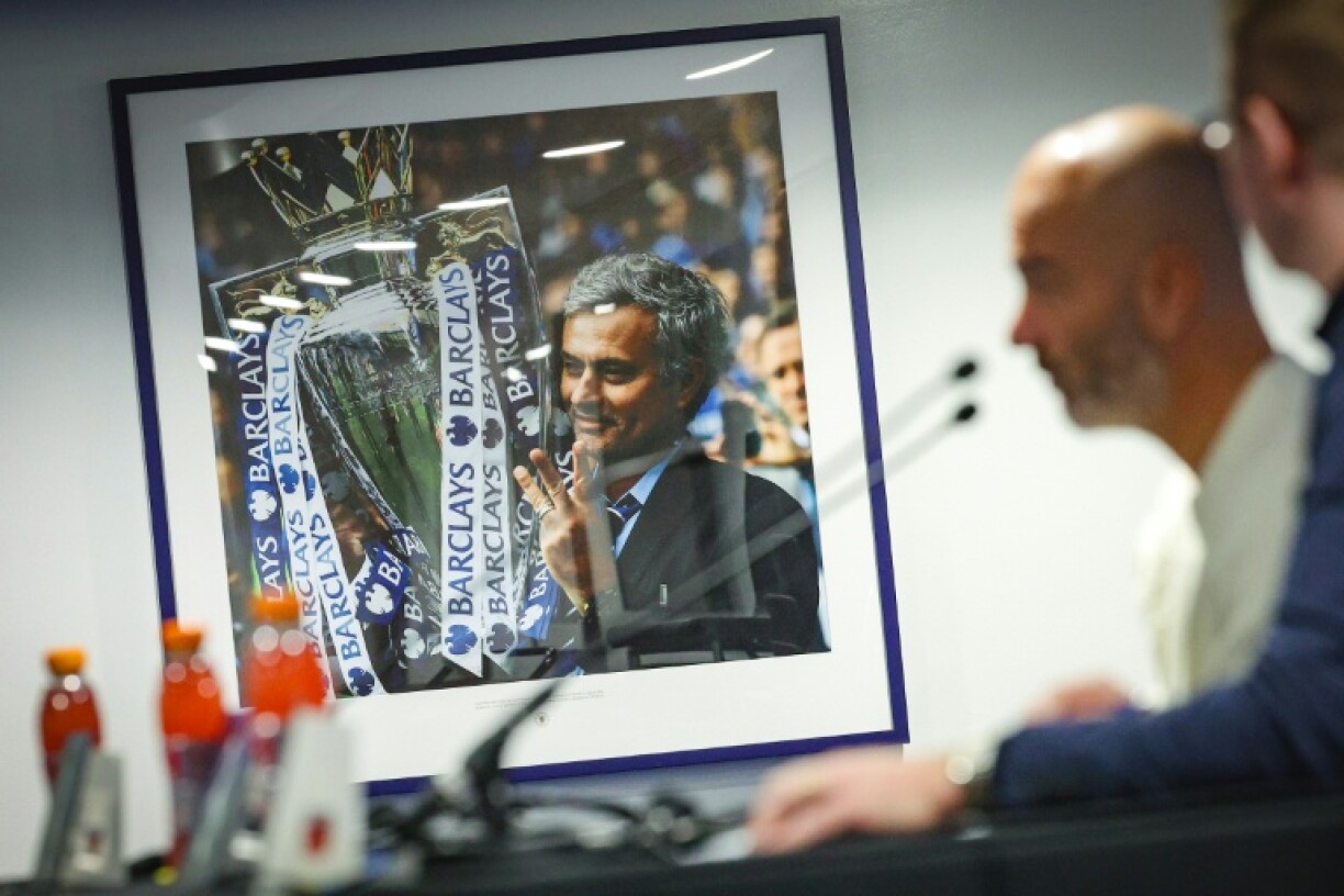 Enzo Maresca speaks at a press conference at Stamford Bridge alongside a photograph of former Chelsea manager Jose Mourinho
