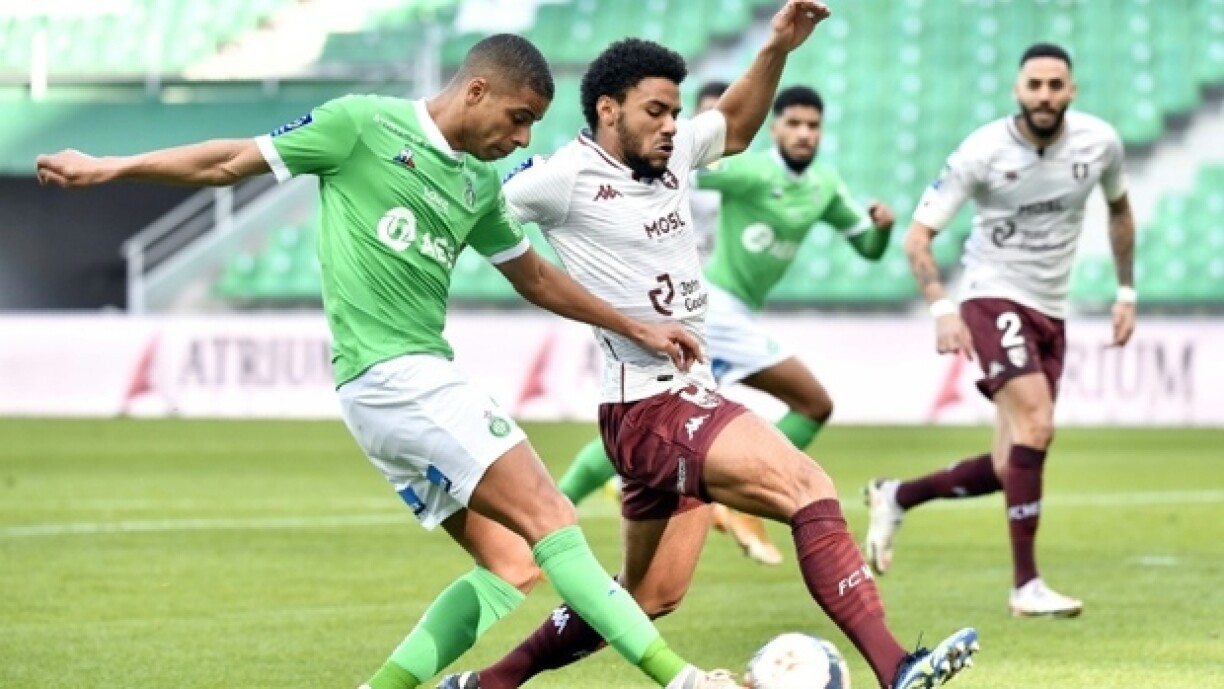 Le milieu de terrain stéphanois Kevin Monnet-Paquet (g), à la lutte avec le défenseur messin Matthieu Udol, lors de leur match de Ligue 1, le 7 février 2021 au Stade Geoffroy-Guichard