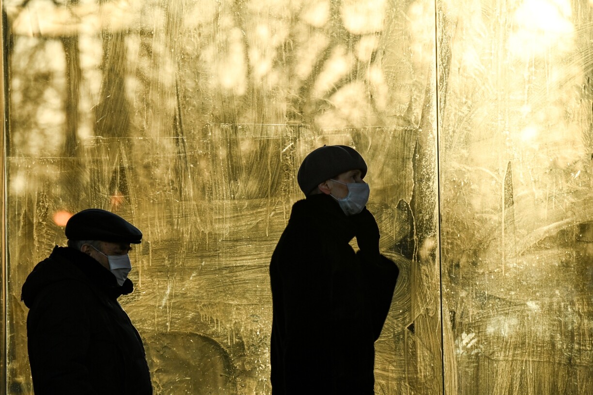 People wearing face masks to protect against the coronavirus disease wait a tram at a tram stop during a cold day in Moscow on December 11, 2020.