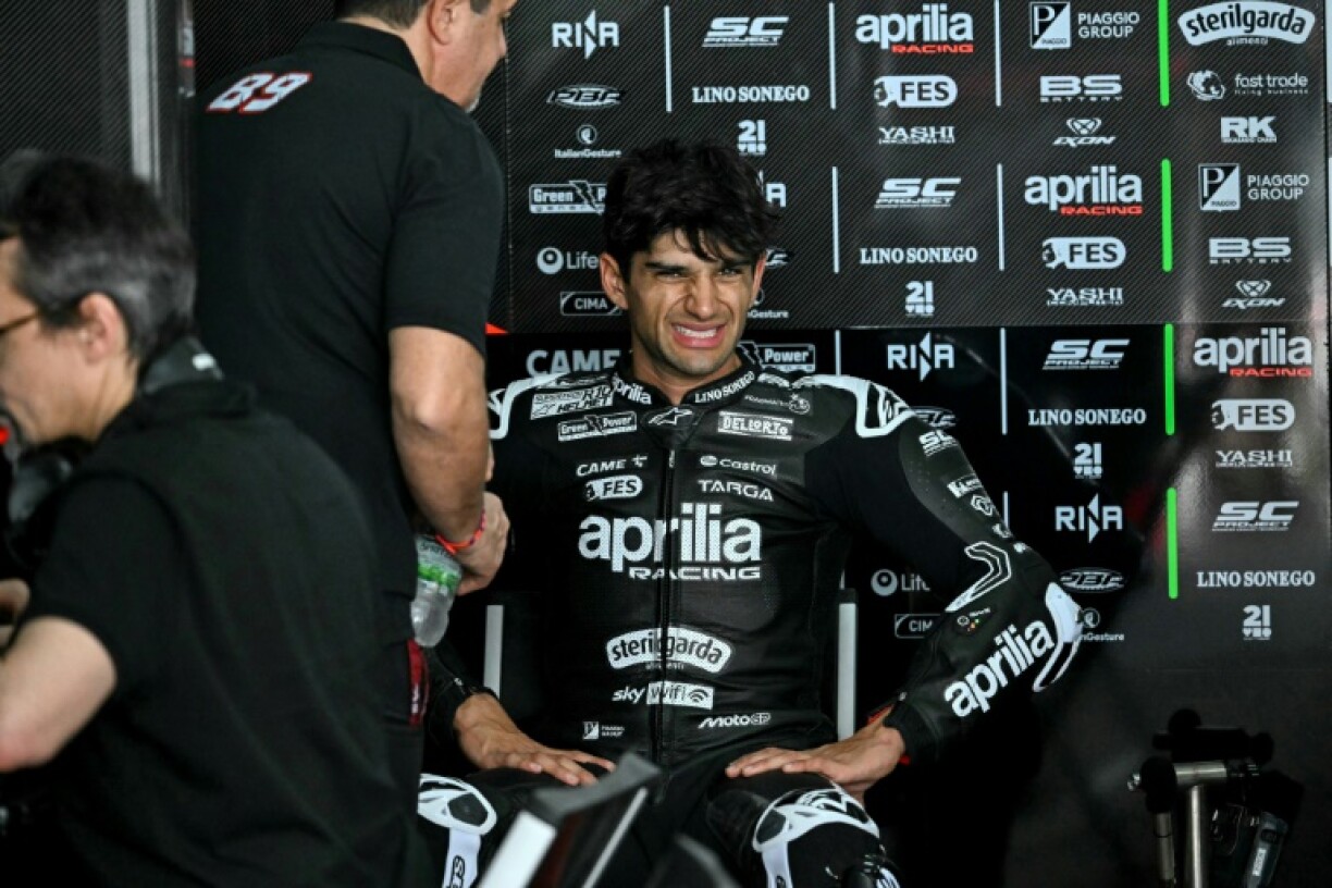 Jorge Martin winces in apparent discomfort in the Aprilia garage during the first day of the 2025 MotoGP pre-season test at the Sepang International Circuit in Malaysia