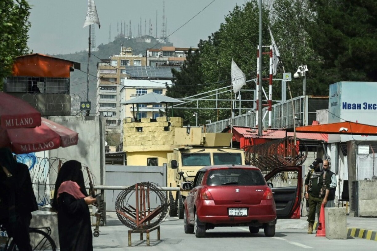 A Taliban security guard inspecting a car outside the Russian Embassy in Kabul on Thursday