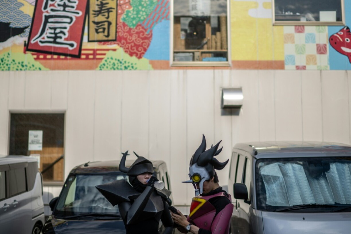 Des cosplayers s'hydratent lors de la deuxième journée du World Cosplay Summit 2026 à Nagoya, le 1er août 2026