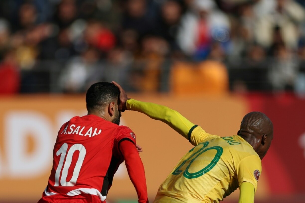 Le défenseur sud-africain Khuliso Mudau porte sa main au visage de l'attaquant égyptien Mohamed Salah, lors d'un match de la CAN-2025, le 26 décembre 2025 à Agadir (Maroc)