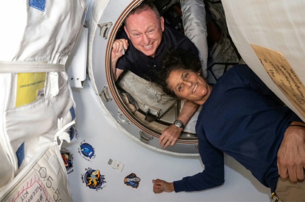 Photo non datée de la Nasa diffusée le 2 juillet 2024 des astronautes Butch Wilmore et Suni Williams (d) à l'intérieur du vestibule entre le port avant du module Harmony de la Station spatiale internationale (ISS) et le vaisseau spatial Starliner de Boeing