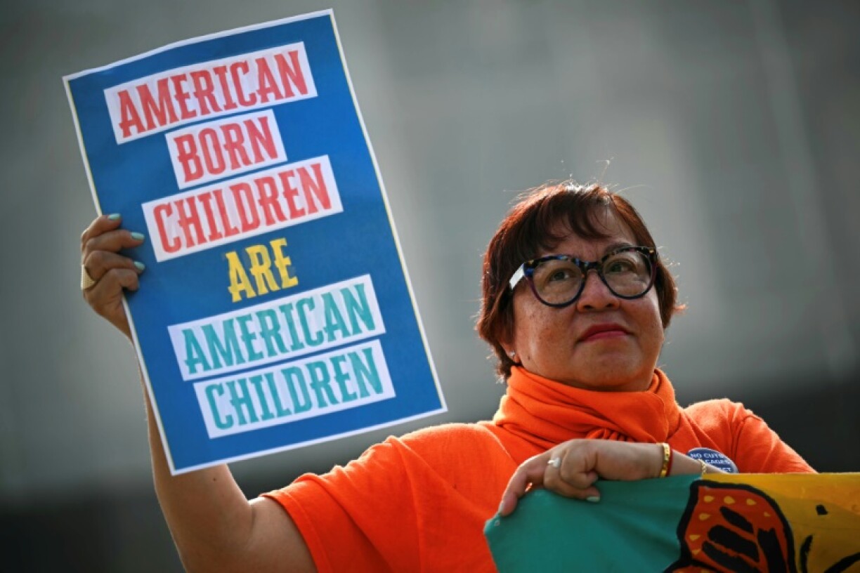 A woman holds a sign during a protest outside the US Supreme Court over President Donald Trump's move to end birthright citizenship