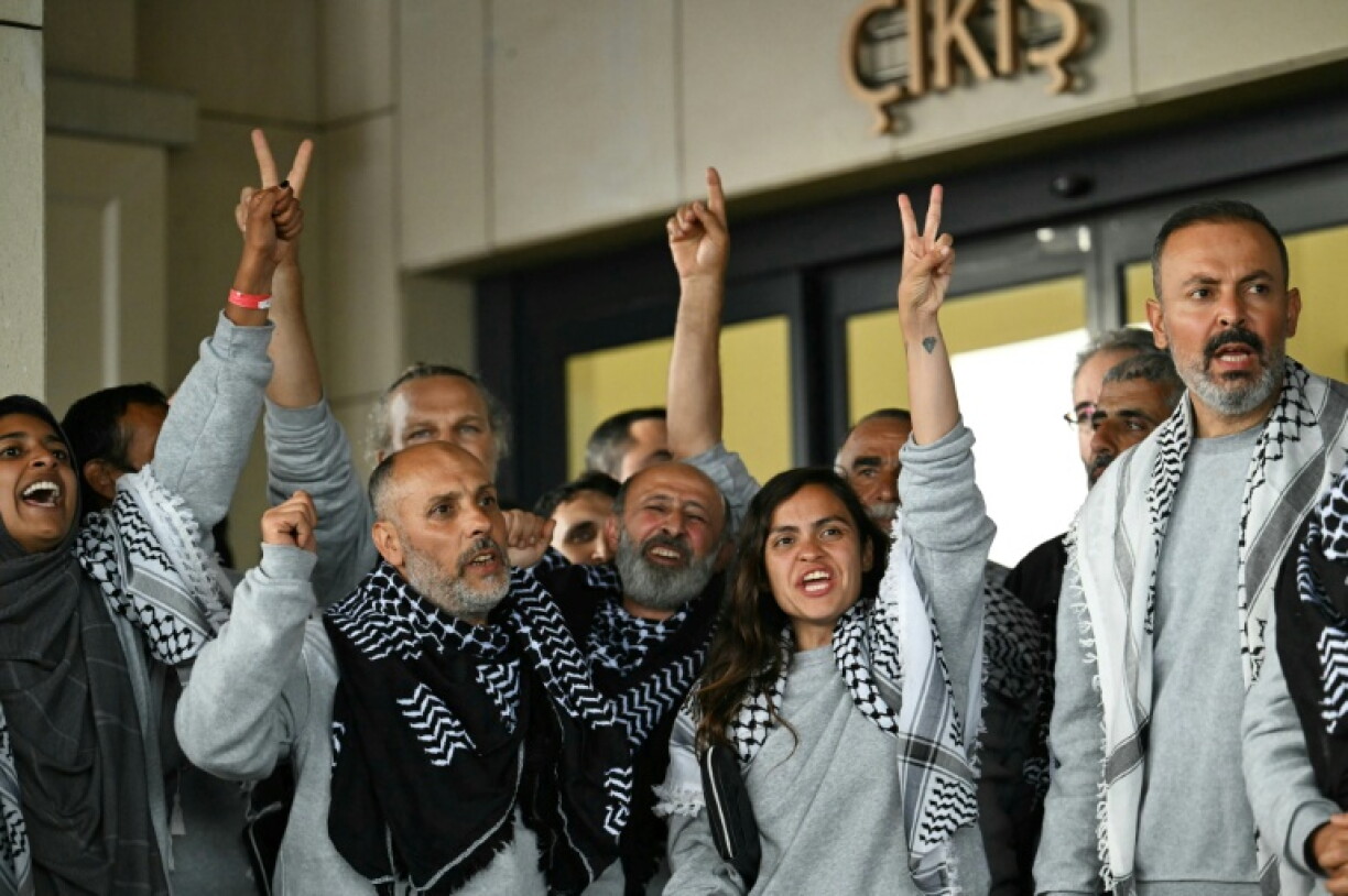 Des militants de la "flottille pour Gaza", arrêtés et expulsés par Israël, devant un terminal après leur arrivée à l'aéroport d'Istanbul, le 21 mai 2026 en Turquie
