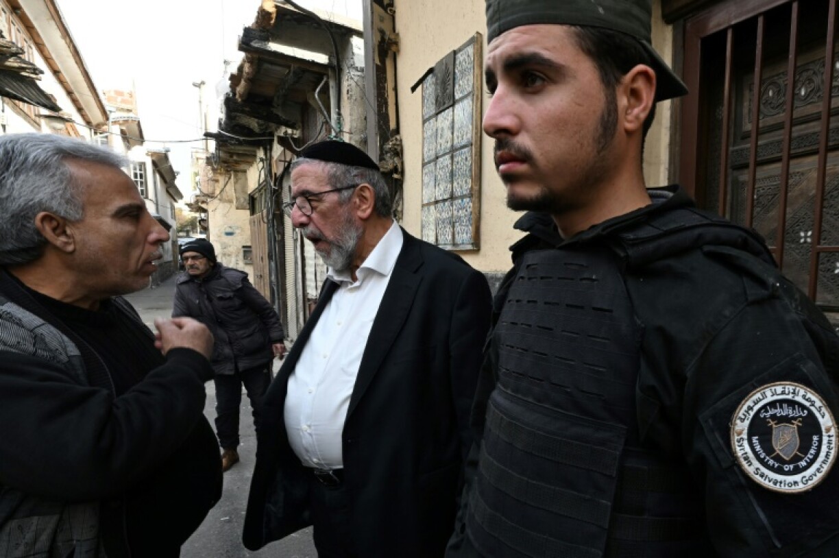 A security guard provided by Syria's new Islamist-led administration stands watch outside for the Jewish prayer.