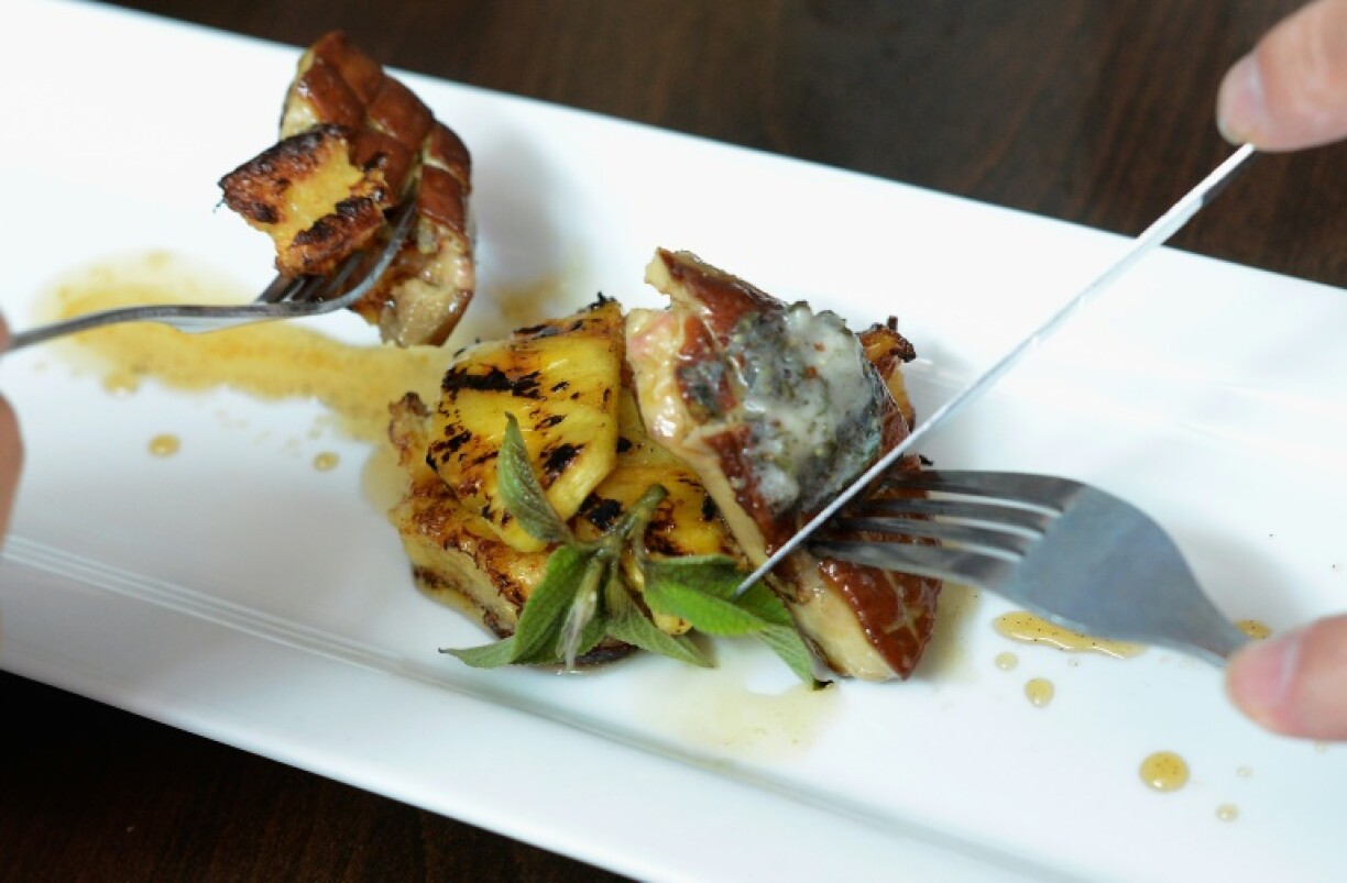 Customers eat gourmet food made with foie gras at Hot's Kitchen during a