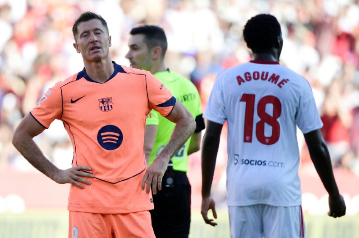 Barcelona's Polish forward Robert Lewandowski (L) stuttered twice in his run-up before firing his penalty wide of the post