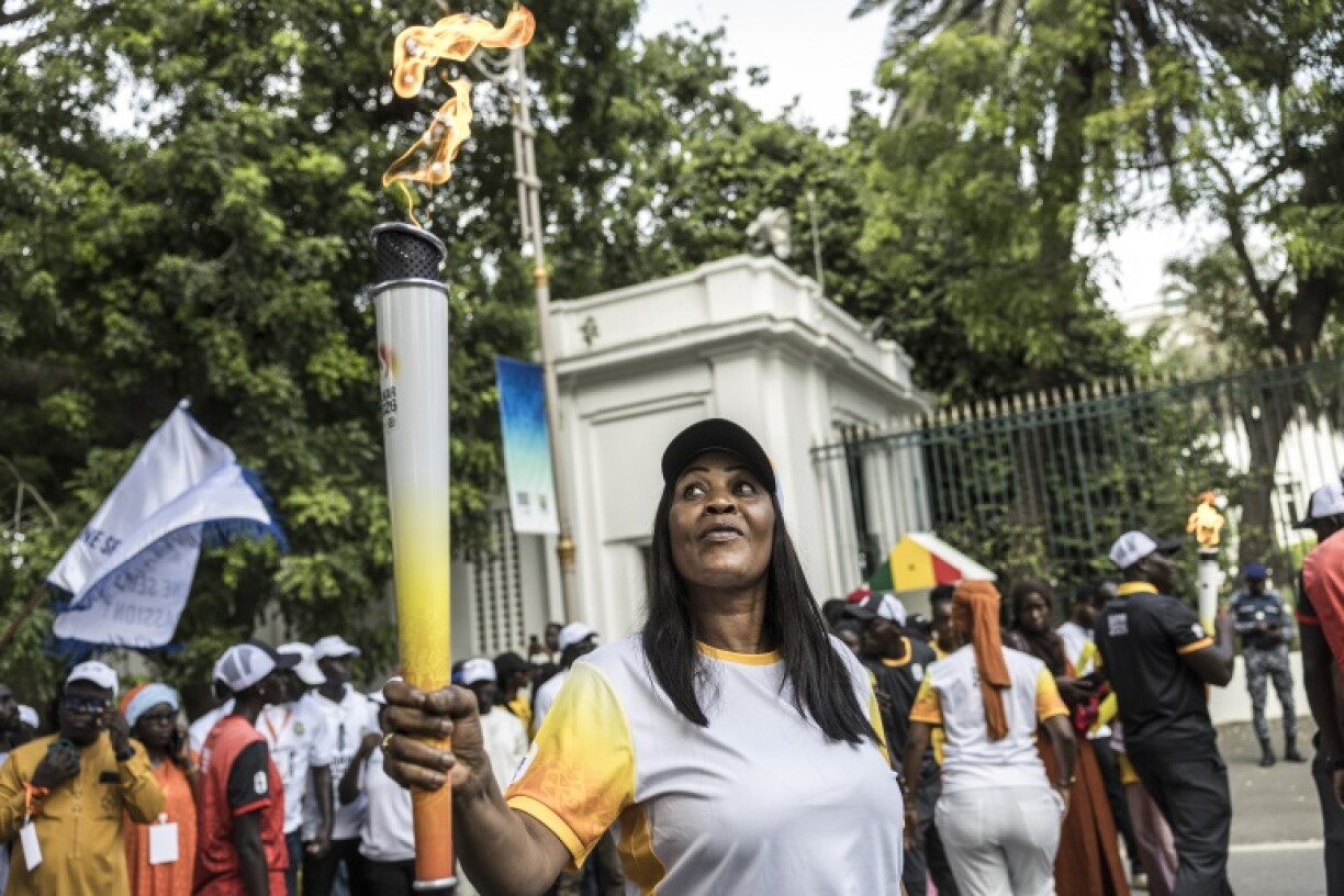 A torch bearer carries the flame for the Youth Olympics in Senegal that start on Saturday