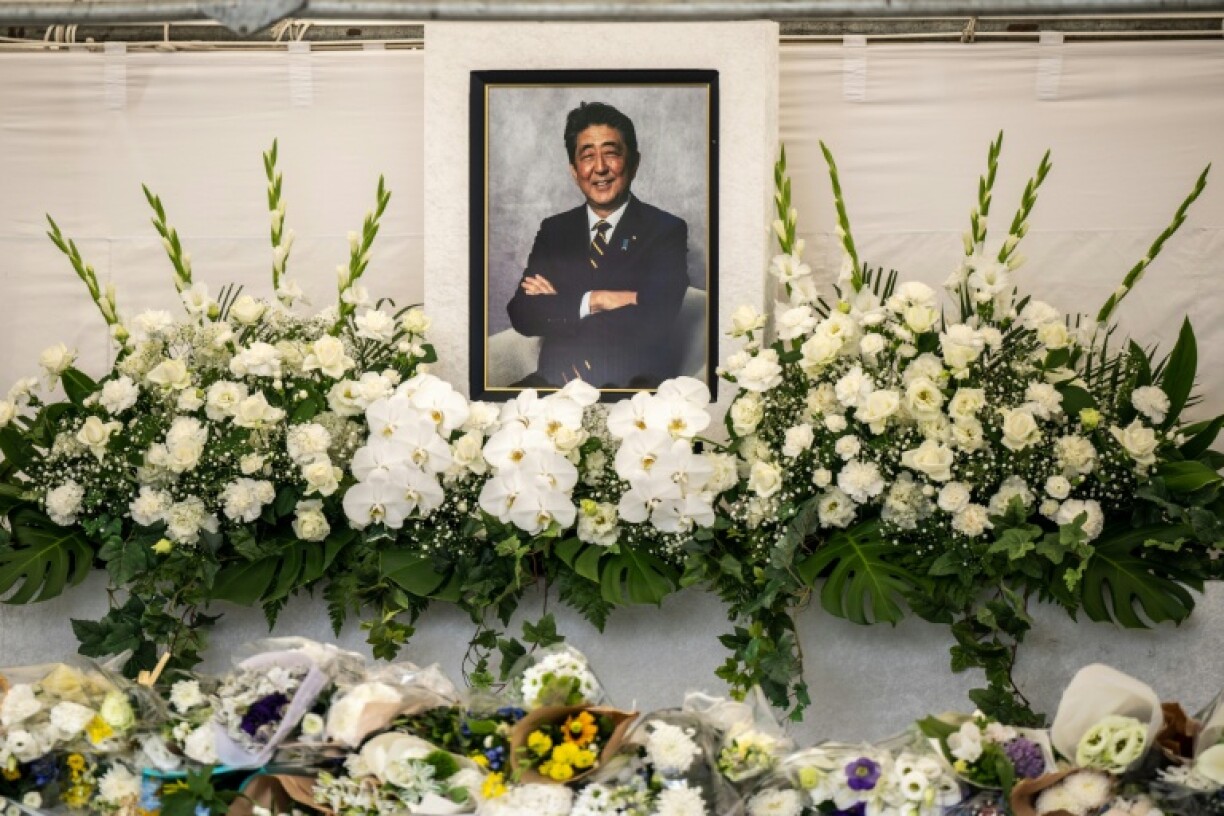 Des fleurs déposées devant un portrait de l'ancien Premier ministre japonais Shinzo Abe lors d'une cérémonie dans un temple, un an après sa mort, le 8 juillet 2023 à Tokyo