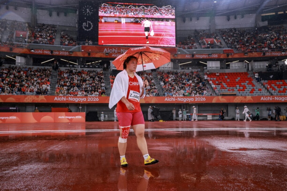 China's Jiang Zhichao walks under an umbrella