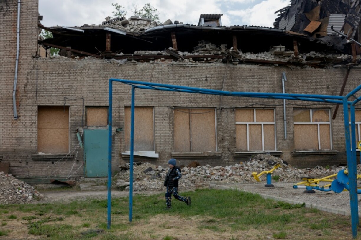 A child walks past a damaged school in Kramatorsk, eastern Ukraine, on May 13