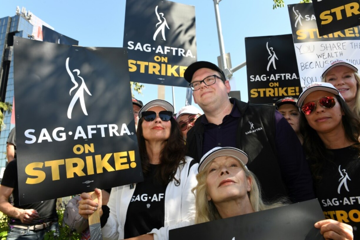 Fran Drescher (c,g), présidente du syndicat des acteurs SAG-AFTRA, et Duncan Crabtree-Ireland (c,d), directeur exécutif national, lors d'une manifestation devant l'immeuble de Netflix, le 14 juillet 2023 à Los Angeles