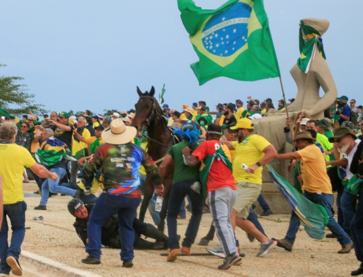 A police officer falls from his horse during clashes with Bolsonaro supporters after an invasion of Planalto Presidential Palace in 2023