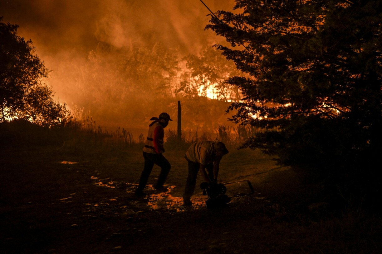 Des habitants d'un village en train de lutter contre un incendie en août 2022 à Covilha au Portugal.
