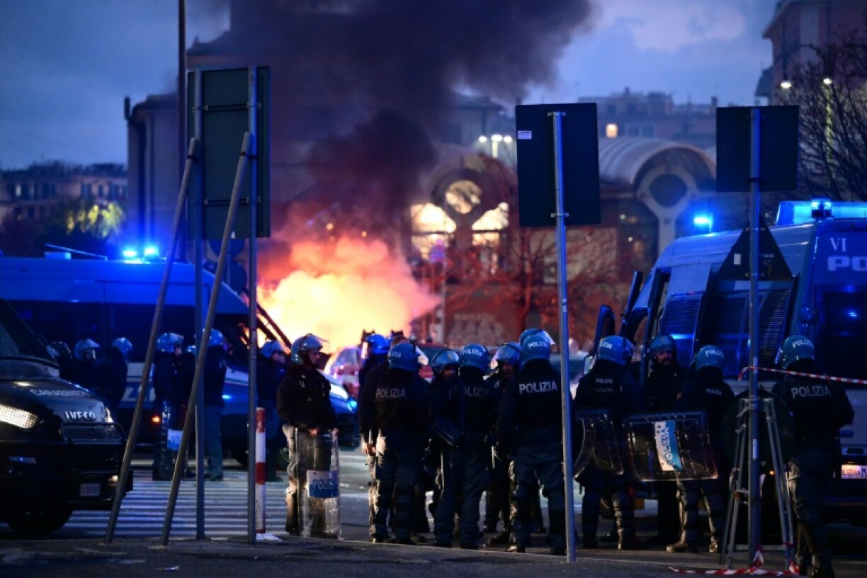 Des policiers devant le stade Luigi-Ferraris interviennent face à des supporters du Genoa et de l'Inter Milan qui ont incendié une voiture le 14 décembre 2025 à Gênes
