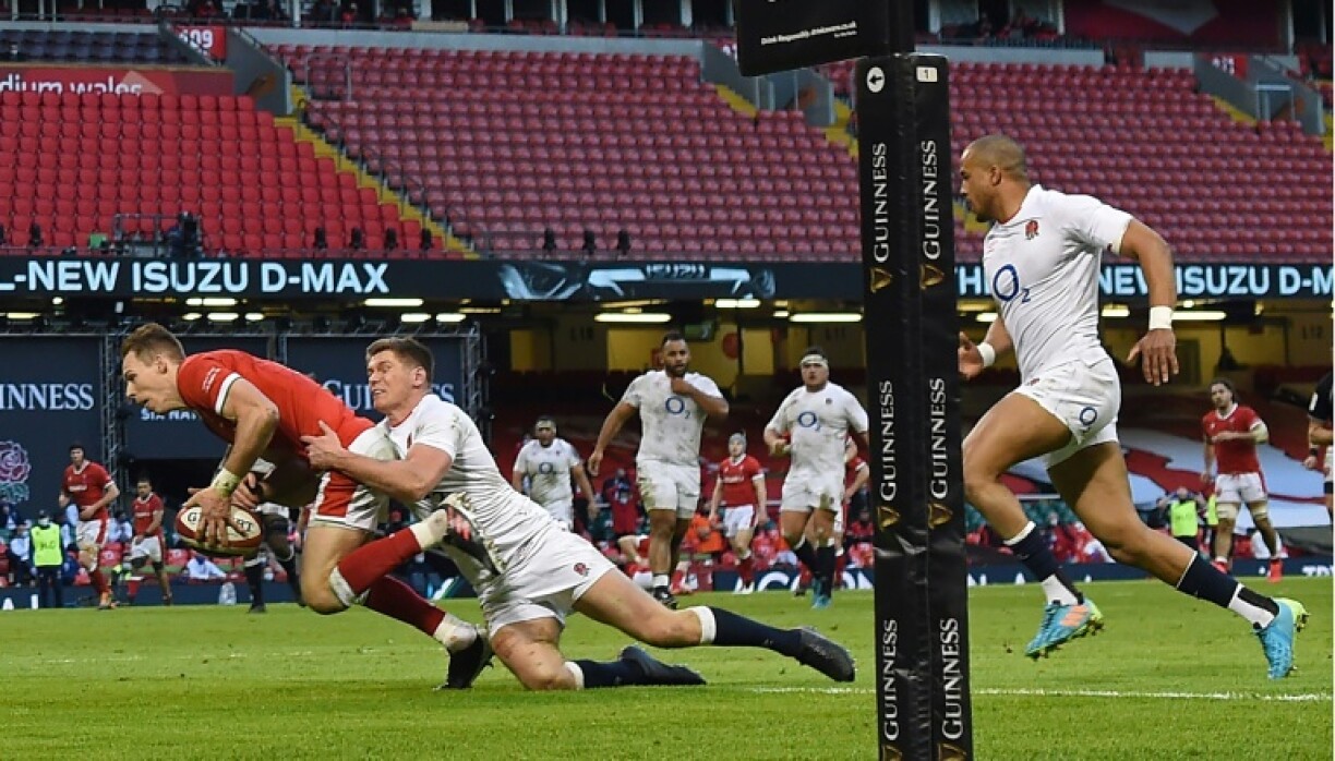 L'arrière gallois Liam Williams marque un essai malgré le plaquage du trois quarts centre anglais, Owen Farrell, lors de leur match du Tournoi des Six nations, le 27 février 2021 au Principality Stadium à Cardiff