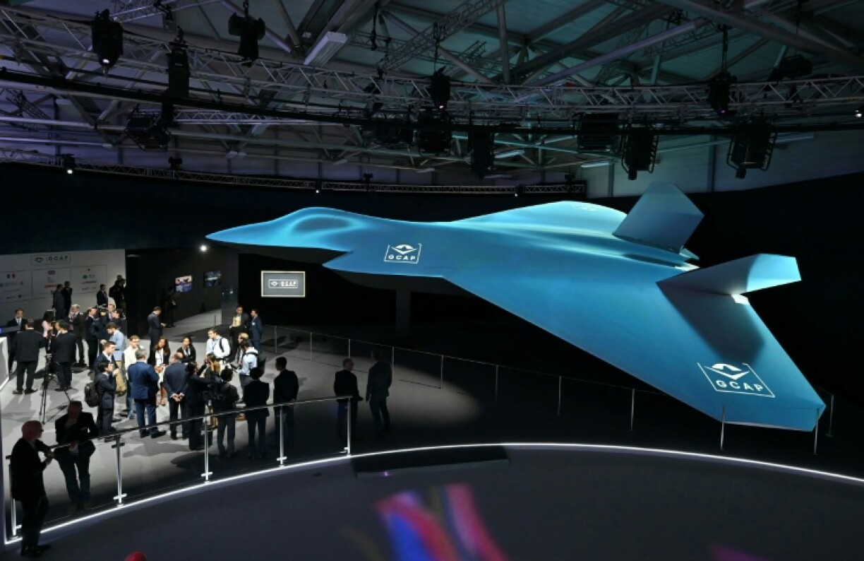 Delegates look at the Global Combat Air Programme (GCAP) 6th generation fighter jet concept design at the Farnborough International Airshow 2024