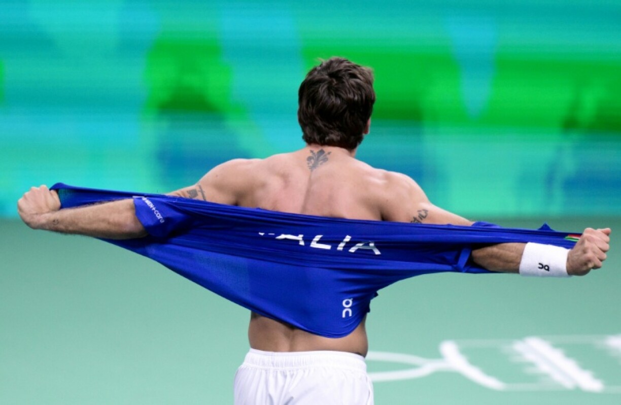 Italy's Flavio Cobolli rips his shirt off after winning his rubber