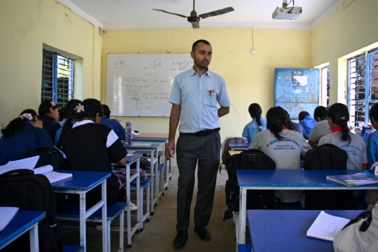 Principal Madhav Lamichhane instructs students during a class at Neelakantha Secondary School following the August 26 flash flood. Each morning teachers are served a painful reminder of the disaster as they call out names of children who never came back