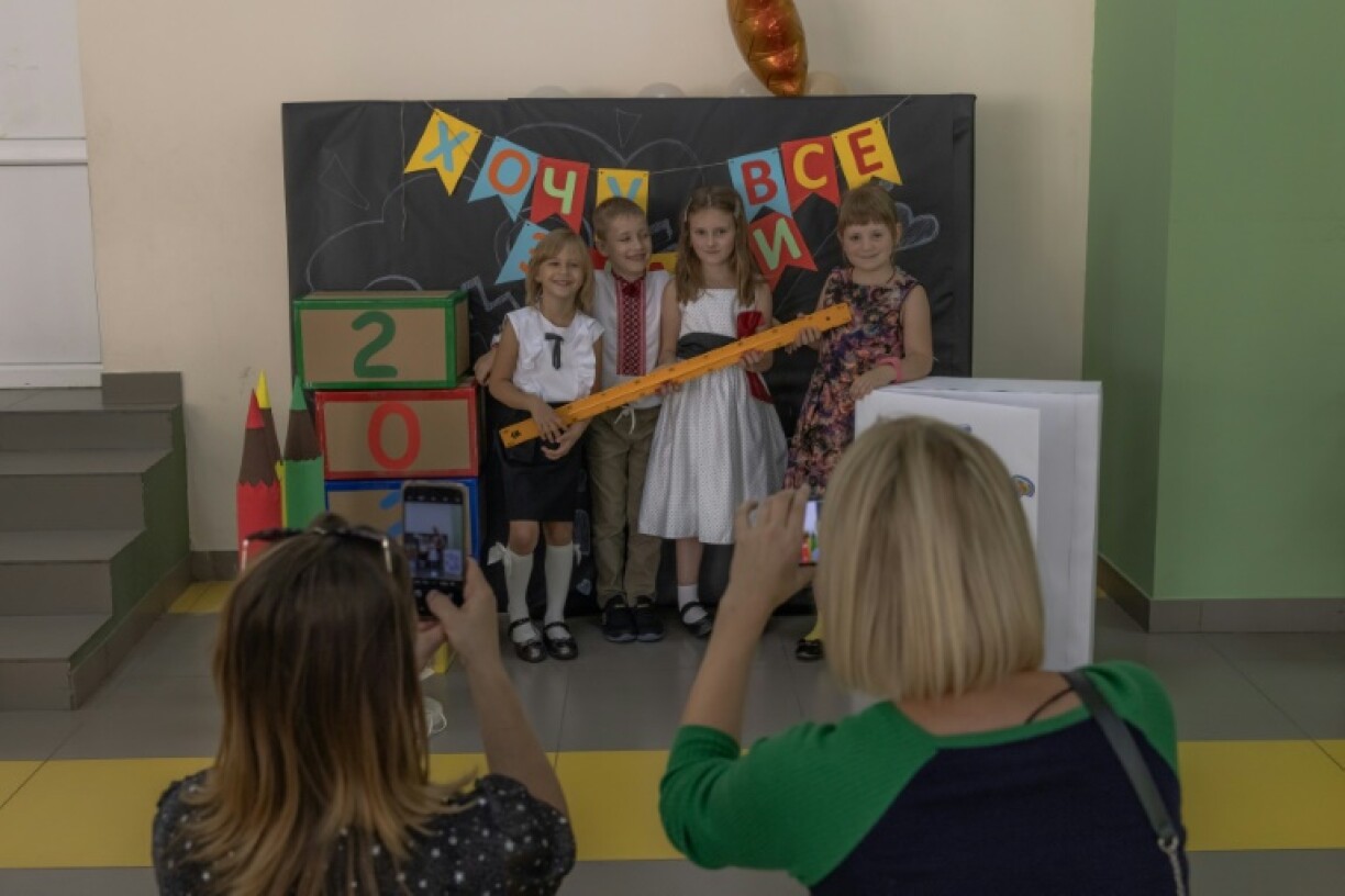 Des élèves posent pour une photo le jour de la rentrée des classes, le 1er septembre 2023 à Irpin, près de Kiev, en Ukraine