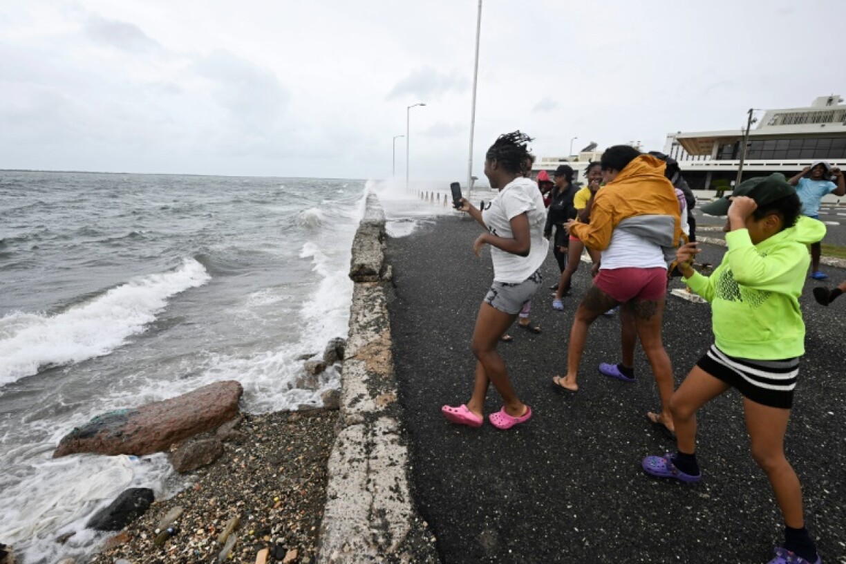 Teenagers gather at the Bank of Jamaica's parking lot on the waterfront in Kingston on October 27, 2025