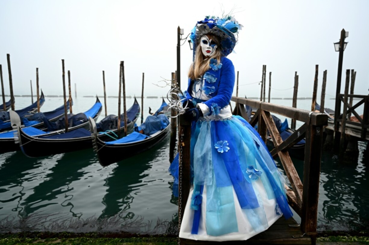 Une femme masquée portant un costume d'époque pose au premier jour des festivités du carnaval de Venise, le 27 janvier 2024.