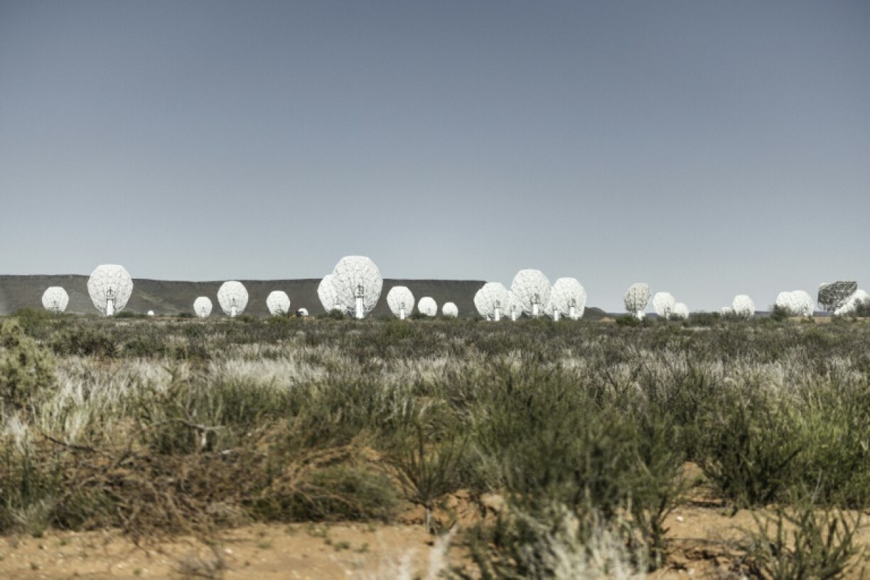 The MeerKAT radio telescope is made up of 64 giant white dishes that stand in a semi-desert region in South Africa