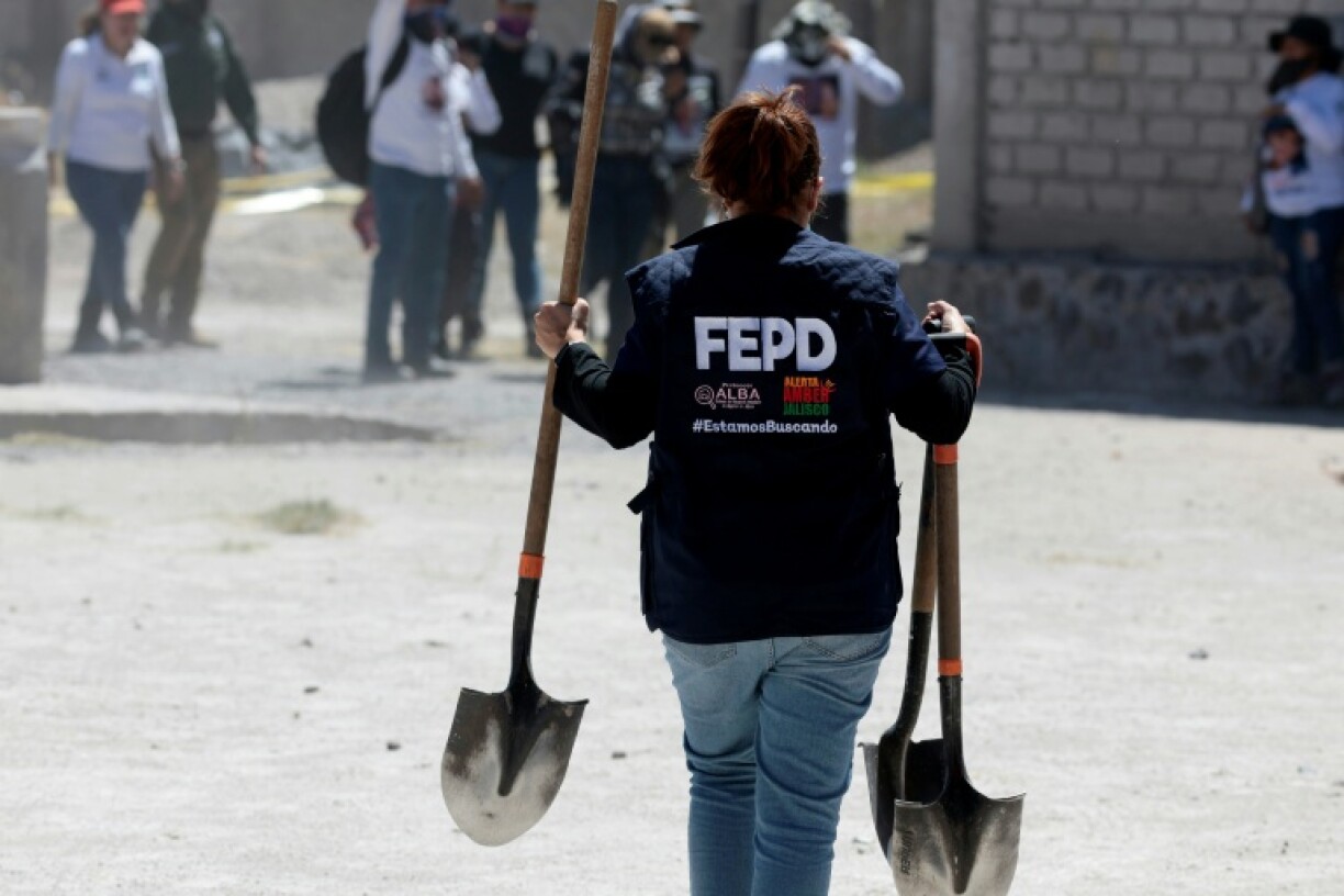 A member of the special prosecutor's office for missing persons carries shovels at the Izaguirre ranch