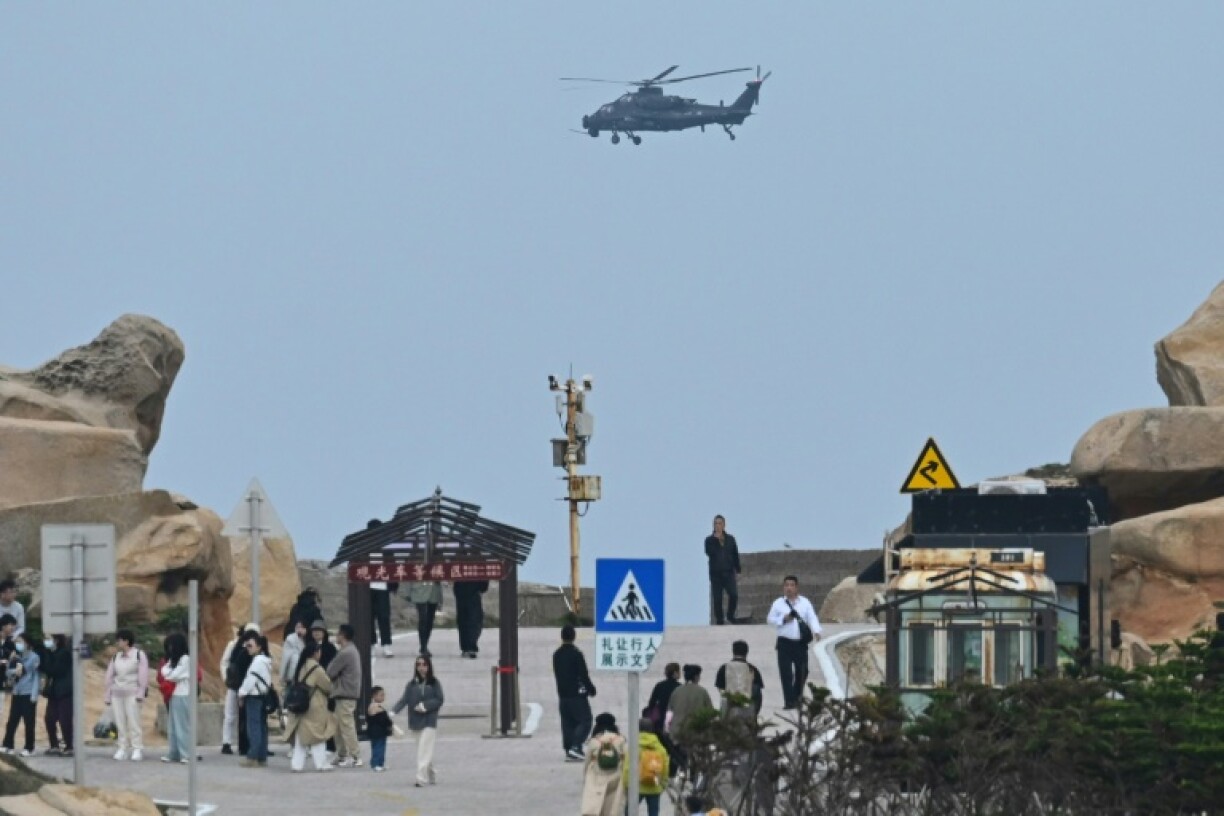 Un hélicoptère militaire chinois survole un point de vue touristique sur le détroit de Taïwan de l'île chinoise de Pingtan, le 7 avril 2023 près de Taïwan
