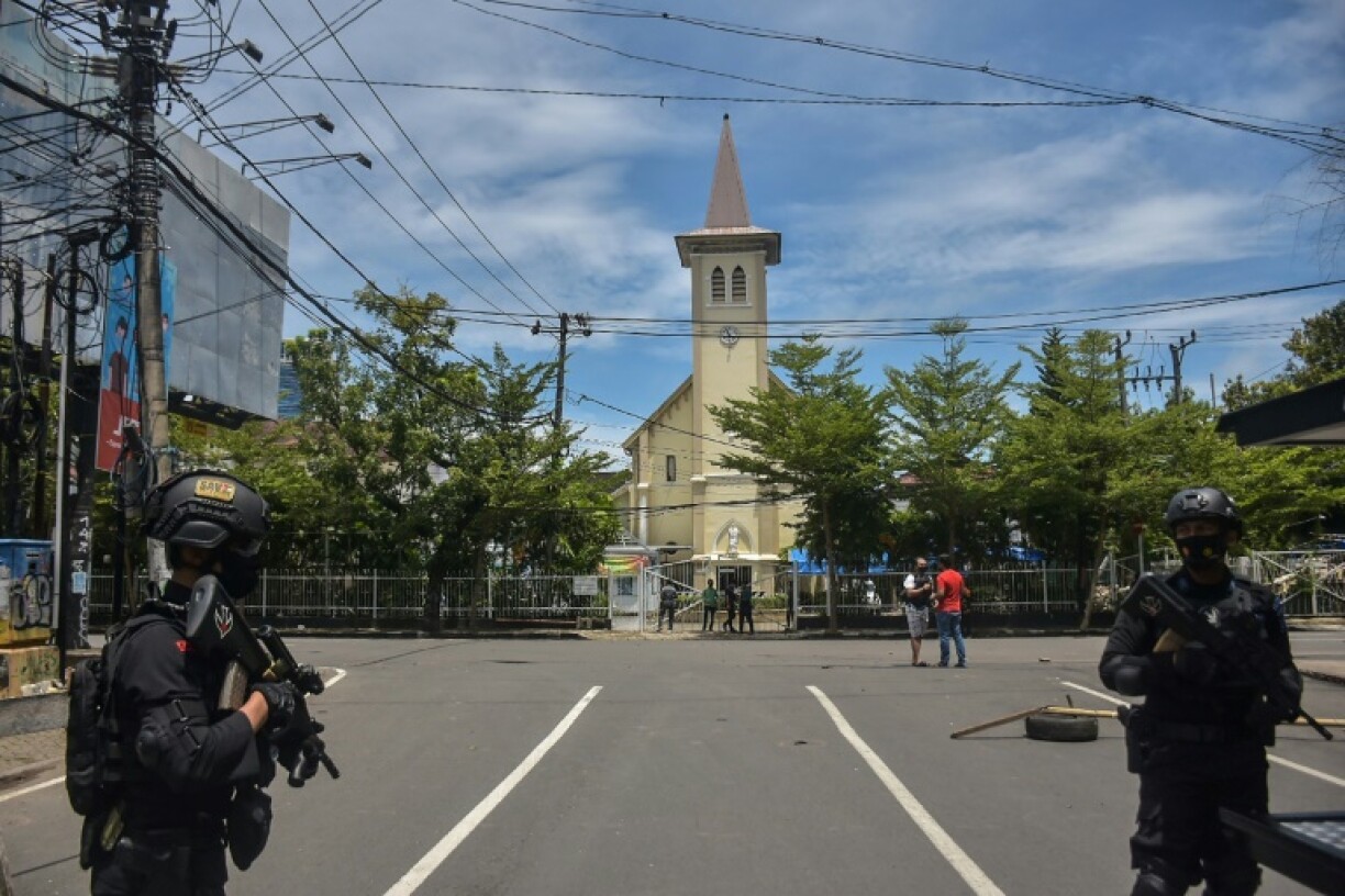Des policiers indonésiens montent la garde après un attentat suicide visant une église, à Makassar, en Indonésie, le 28 mars 2021