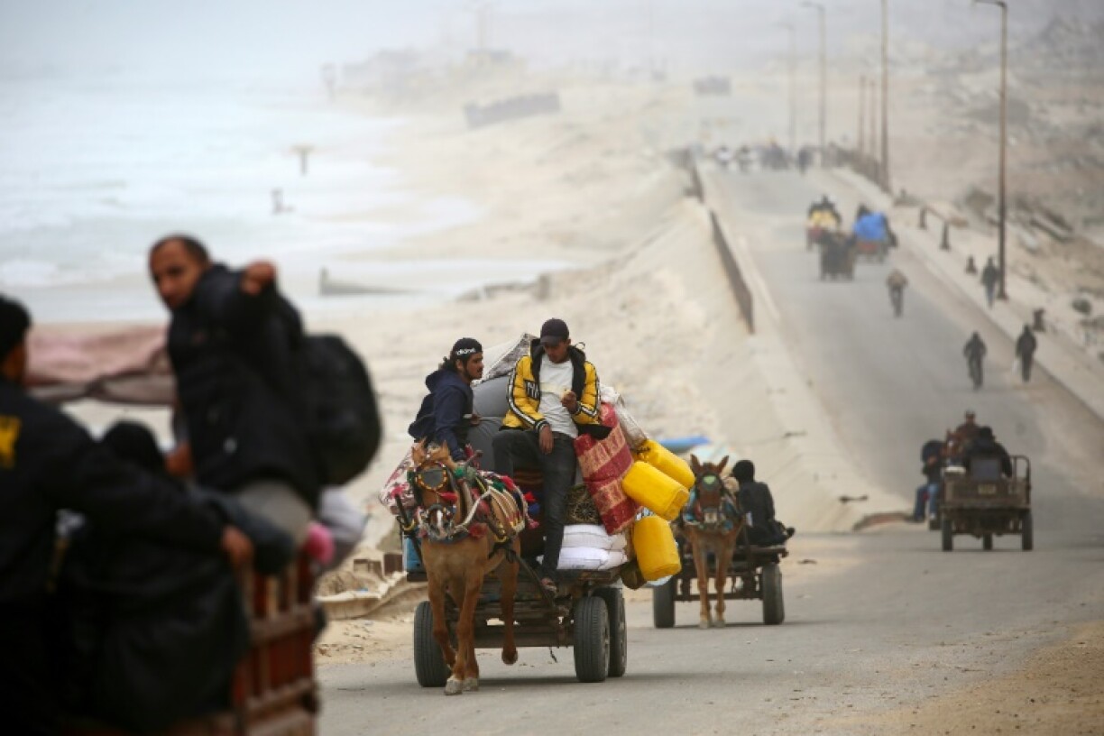 Palestinians ride vehicles with their belongings as they flee from the northern Gaza Strip toward the south