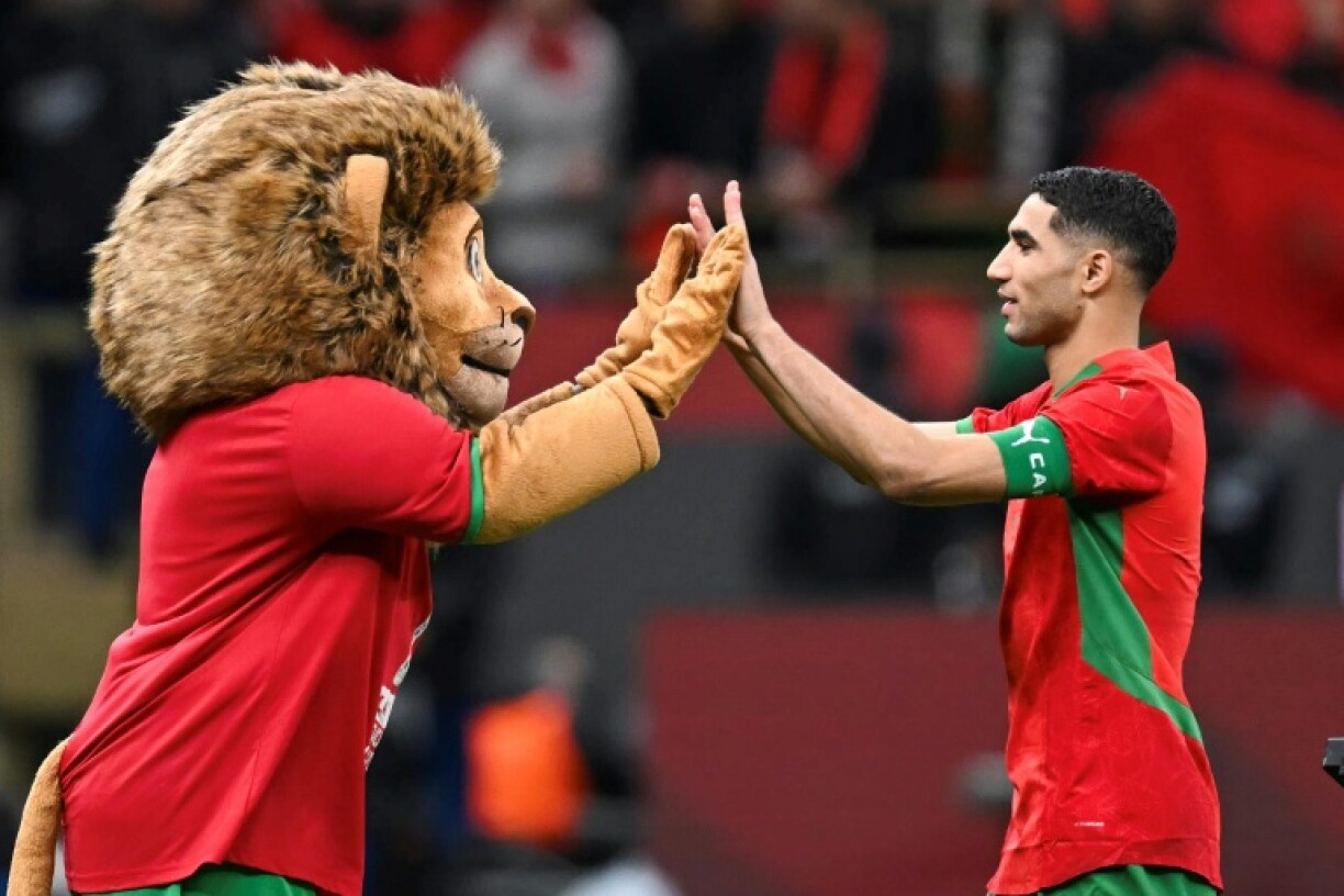 Le capitaine du Maroc Achraf Hakimi et la mascotte de la CAN-2025 après la demi-finale remportée aux tirs au but face au Nigeria, le 14 janvier 2026 à Rabat