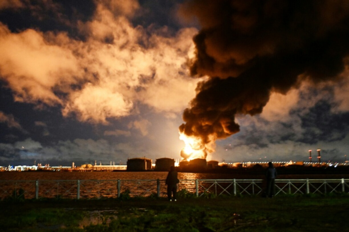 People watch a fire at a major oil terminal in Saint Petersburg, Russia following an air attack